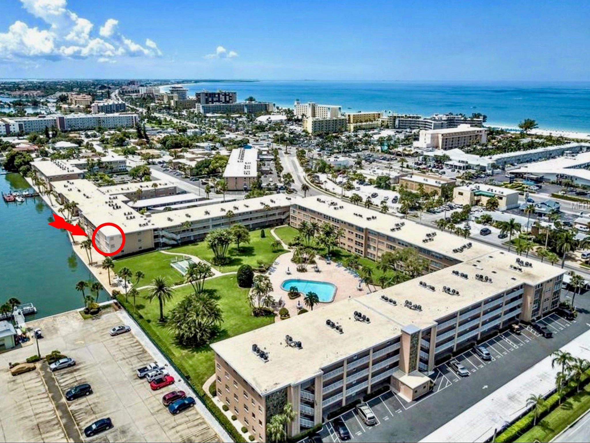 Aerial view of beachfront resort with pool and sandy beach