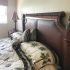 Neatly made bed with dark wooden headboard